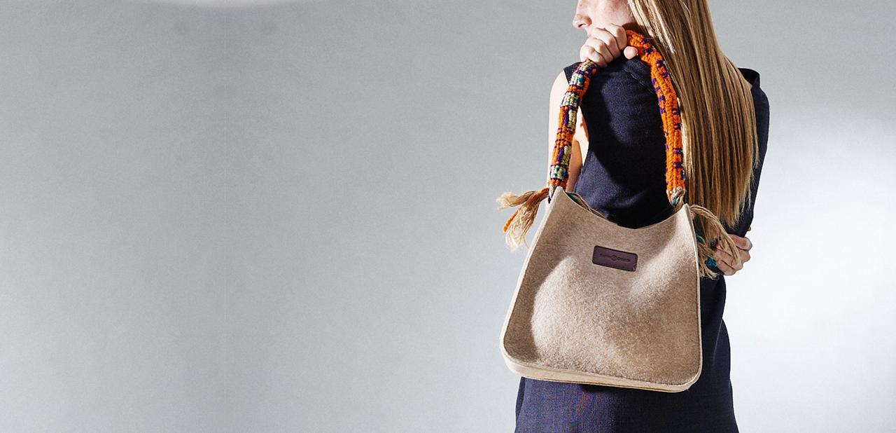 Model carrying an Ottaner felt bag with woven handle